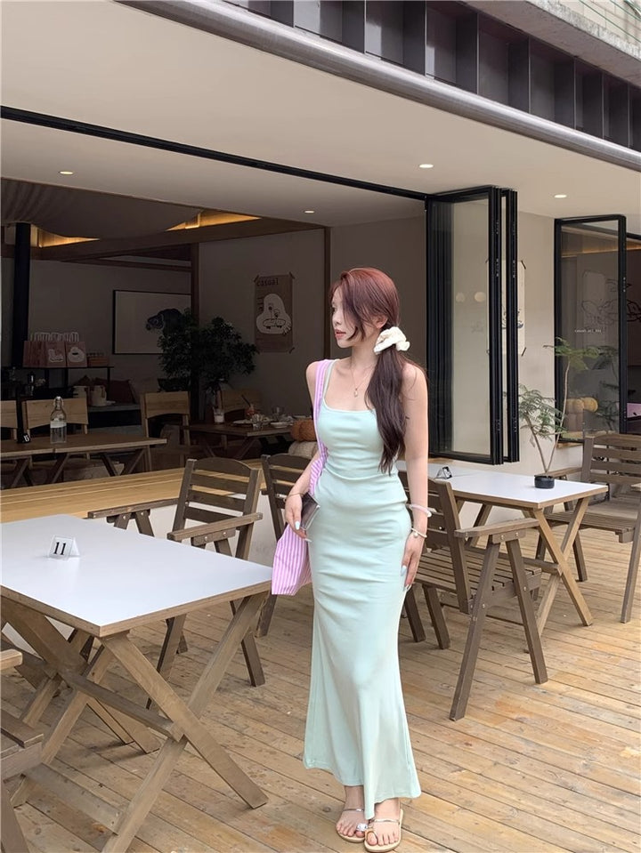 An elegant, fitted, backless dress; a long, form-fitting skirt.
