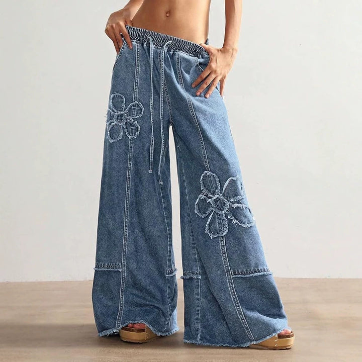 High-street style, high-waisted, embroidered floor-length jeans—a trendy piece