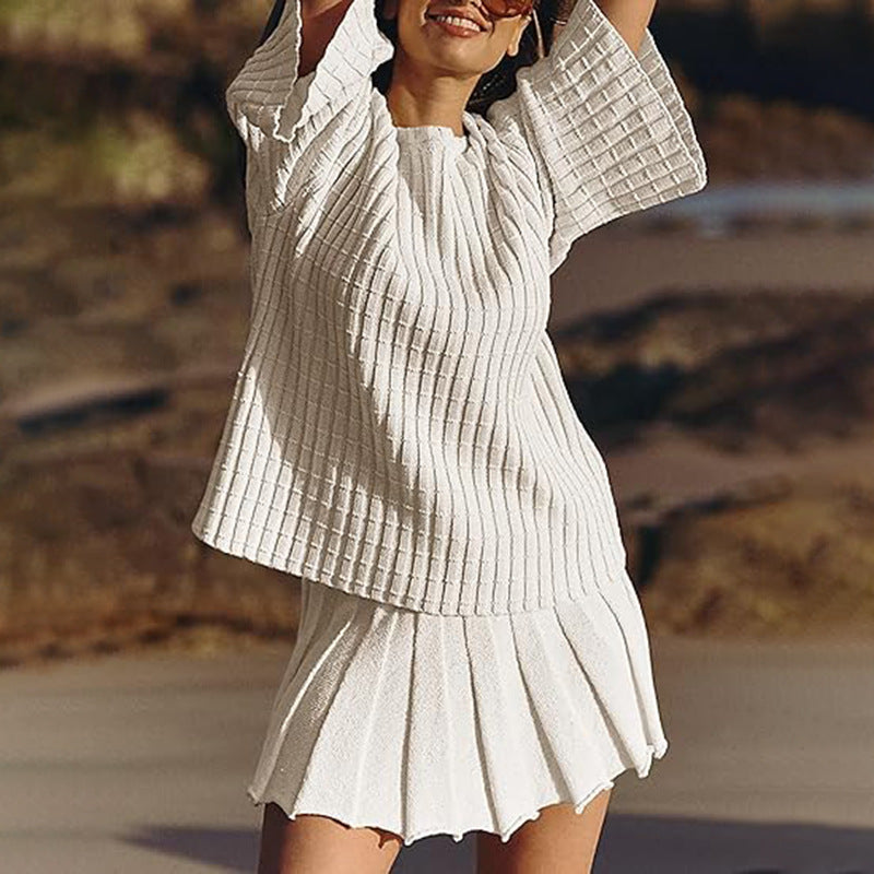 Relaxed-fit two-piece set: long-sleeved knit top and pleated skirt.