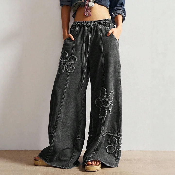 High-street style, high-waisted, embroidered floor-length jeans—a trendy piece