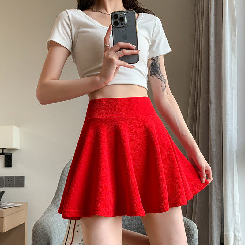 The new pleated skirt is paired with a loose white shirt featuring a tie-back detail.