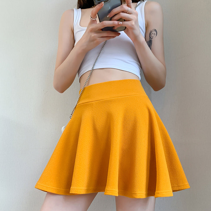 The new pleated skirt is paired with a loose white shirt featuring a tie-back detail.