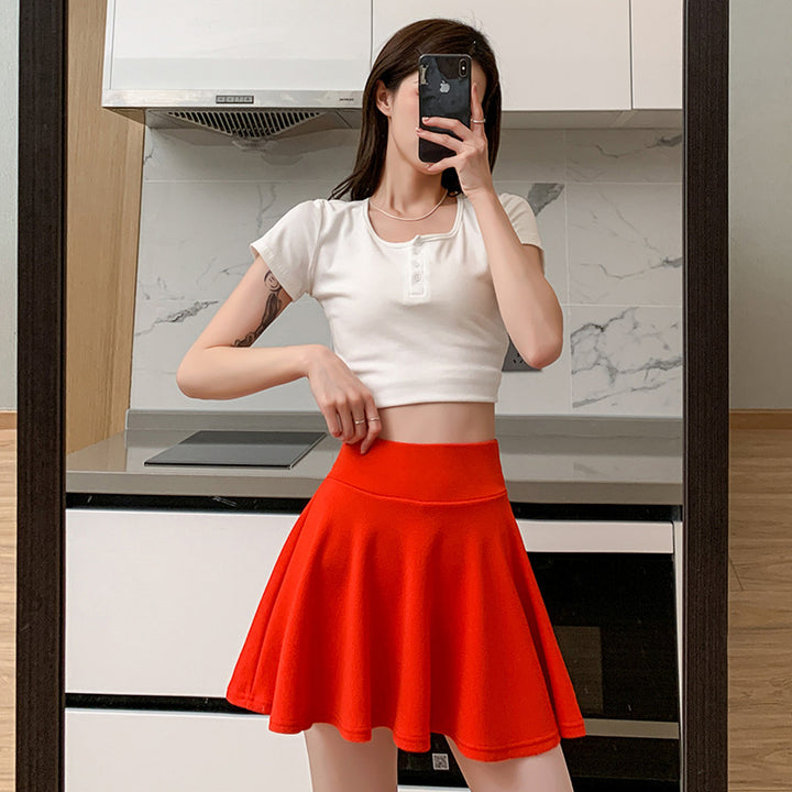 The new pleated skirt is paired with a loose white shirt featuring a tie-back detail.
