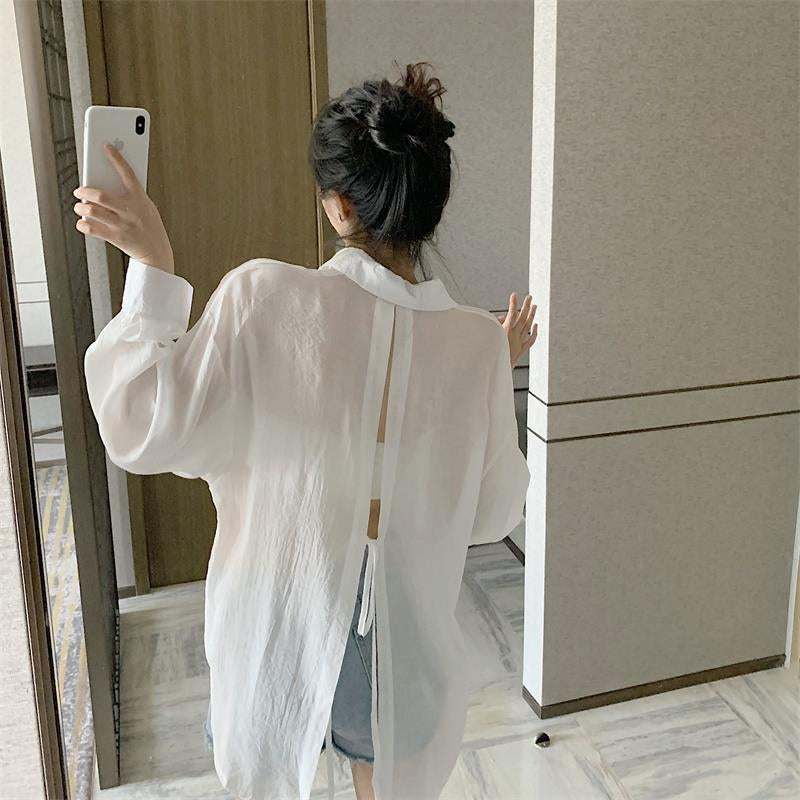 The new pleated skirt is paired with a loose white shirt featuring a tie-back detail.
