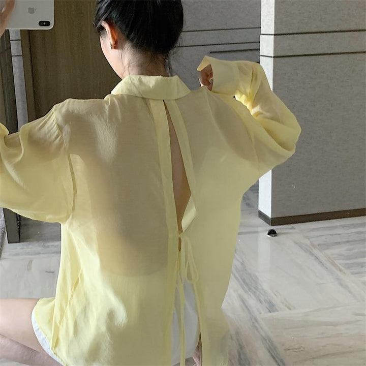 The new pleated skirt is paired with a loose white shirt featuring a tie-back detail.